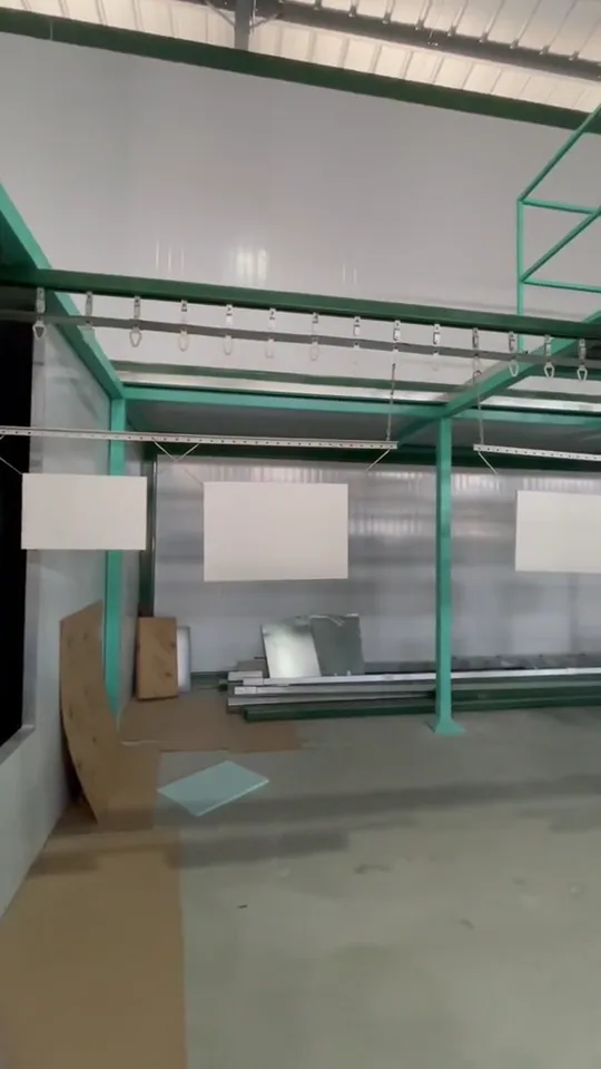 Panels suspended from green overhead rails in the workshop